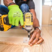 Free Person Using Dewalt Cordless Impact Driver on Brown Board Stock Photo