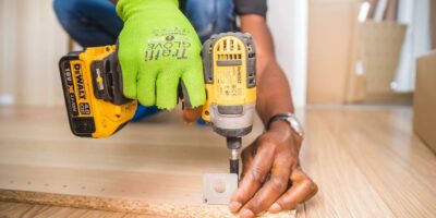 Free Person Using Dewalt Cordless Impact Driver on Brown Board Stock Photo